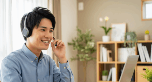 在宅勤務でヘッドセットマイクを使用し、笑顔でオンライン会議に参加する男性