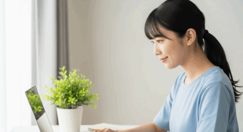 自宅の明るいデスクで、女性がノートパソコンを開き、新しいことを始める瞬間の、希望に満ちた横顔